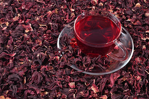 Cup of hibiscus tea in a heap of dried petals of hibiscus Cup of hibiscus tea in a heap of dried petals of hibiscus